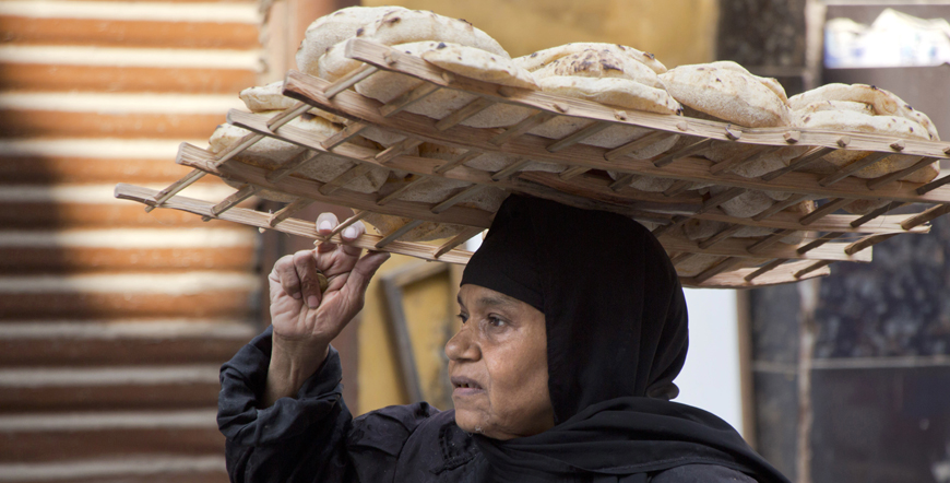 An Egyptian carries bread tray in the neighbourhood of Al Gamaliah in Cairo, Egypt, on Friday (AP photo)